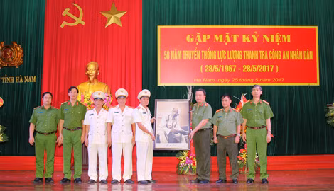 Đại tá Nguyễn Văn Trung, Giám đốc Công an tỉnh Hà Nam tặng bức ảnh Chủ tịch Hồ Chí Minh và trao hoa chúc mừng Thanh tra Công an tỉnh Hà Nam nhân 50 năm Ngày truyền thống ngành Thanh tra CAND.