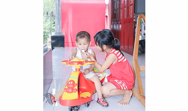 Bé Huyền giúp cha chăm sóc em trai Quốc Huy.