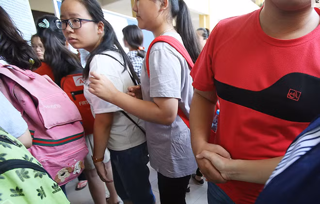 Cái bắt tay chắc chắn của người mẹ dành cho con trai khi cậu chuẩn bị bước vào phòng thi.
