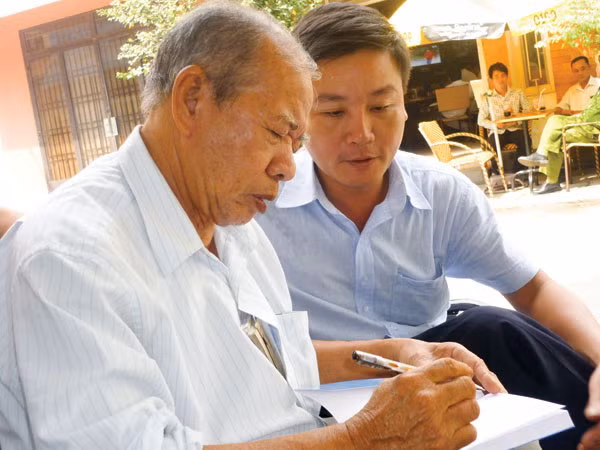 Nhà thơ Phạm Thiên Thư (trái) và tác giả tại quán cà phê “Động hoa vàng”.