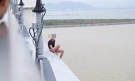 Nạn nhân ngồi trên thành cầu.
