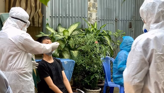Nhân viên y tế lấy mẫu xét nghiệm những người từ vùng dịch đến thành phố.