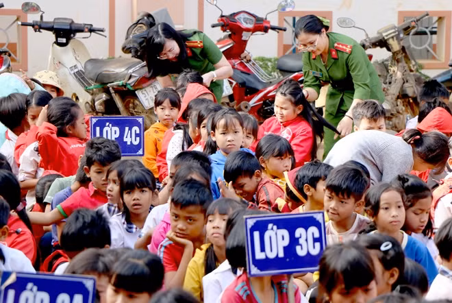 Các nữ cán bộ Công an quan tâm đến các em học sinh.