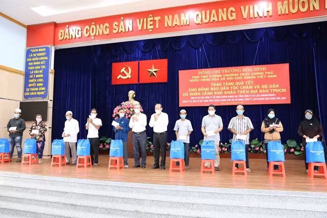 Phó Thủ tướng Thường trực và đồng chí Phó Chủ tịch UBND TP Hồ Chí Minh trao tặng quà Tết cho người dân.