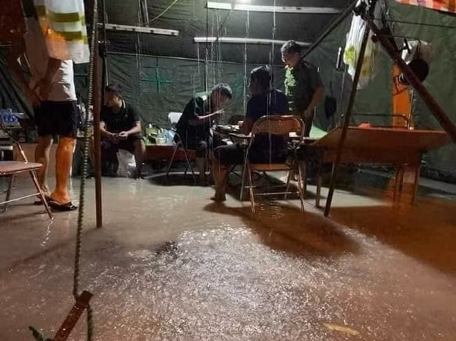 Mưa lớn ngập nước, cán bộ chiến sĩ tại chốt kiểm soát dịch lội nước ăn cơm.