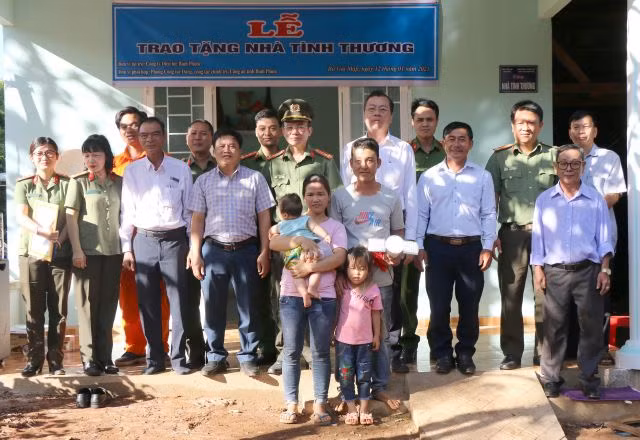 Gia đình anh Thái và khách mời chụp hình lưu niệm trước căn nhà tình thương vừa được trao tặng.