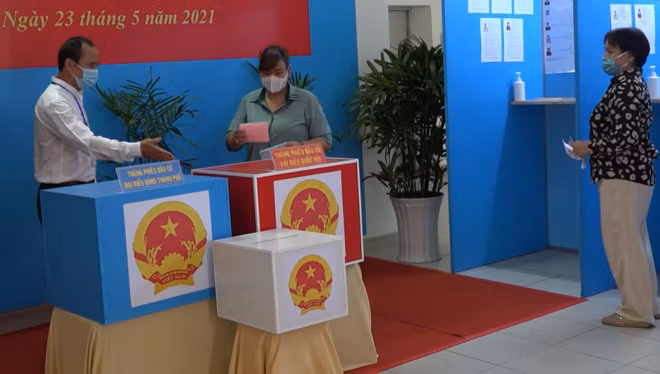 Cán bộ hướng dẫn cử trị bỏ phiếu đúng thùng phiếu.