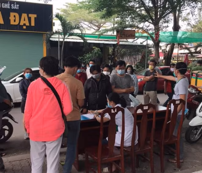 Nhân viên y tế lập danh sách và lấy mẫu xét nghiệm cư dân chung cư.