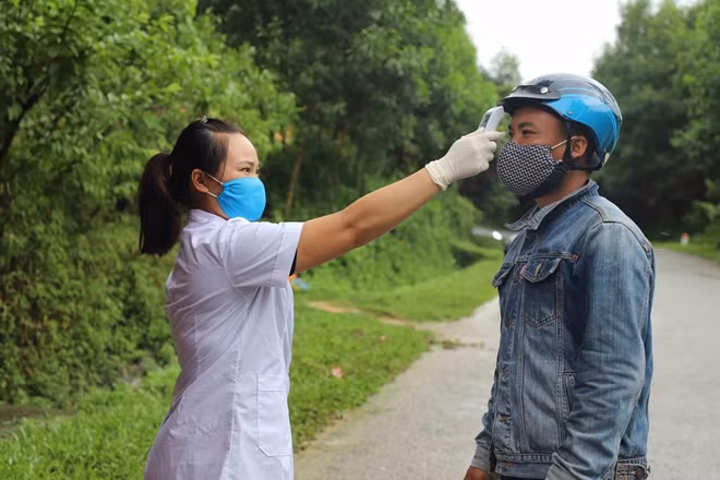 Nhân viên y tế kiểm tra thân nhiệt người dân