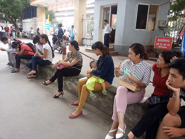 Chị Hoa (Thái Bình) và con gái gần 1 tuổi ngồi trước cổng trường đợi dì đi rút hồ sơ. Chị Hoa (Thái Bình) và con gái gần 1 tuổi ngồi trước cổng trường đợi dì đi rút hồ sơ.