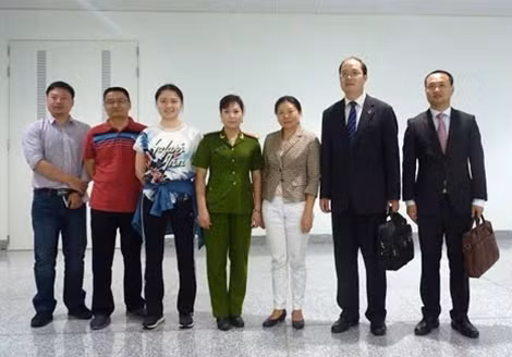 Đối tượng truy nã Chu Lai Ying Susan (Đối tượng mặc áo vest nâu, thứ 3 bên phải ảnh) được cơ quan chức năng Việt Nam bàn giao cho Công an Trung Quốc tại sân bay Quốc tế Nội Bài.