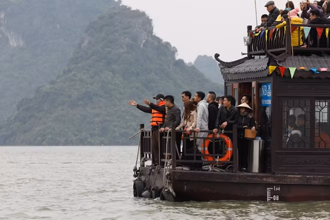 Nhân viên trên thuyền ra hiệu mở đường trên bờ cho thuyền cập bến
