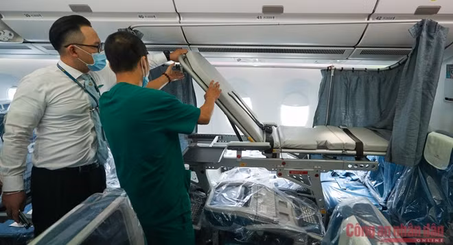 Nhân viên y tế cùng tiếp viên kiểm tra lại giường cấp cứu được lắp đặt trên máy bay.