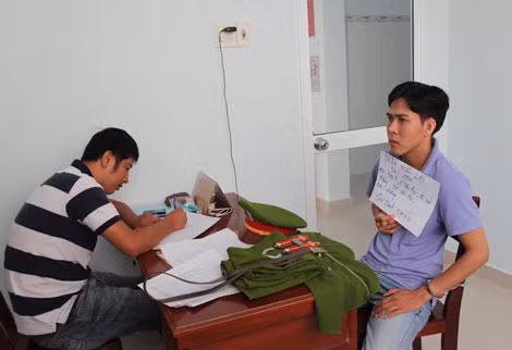 Đối tượng Lợi (bìa phải) đang làm việc với cơ quan chức năng.