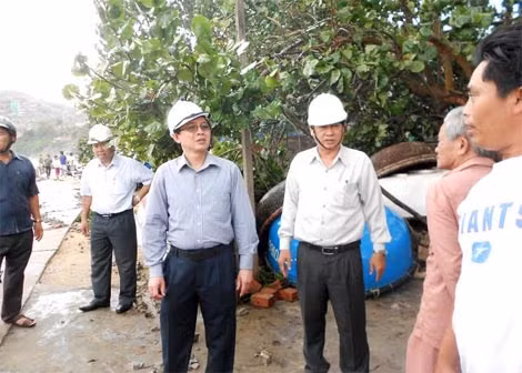 Chủ tịch UBND tỉnh Hồ Quốc Dũng (thứ hai, từ phải qua) kiểm tra, chỉ đạo công tác khắc phục hậu quả cơn bão số 4 tại xã Nhơn Lý sáng 30/11.