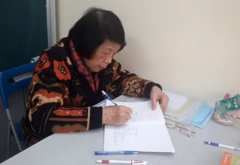 Bà giáo Nguyễn Thị Côi đang chấm bài cho các em nhỏ