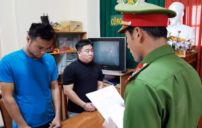 Công an TP Đà Lạt đọc lệnh bắt tạm giam Lê Hải Nam (áo đen) và Lưu Văn Thiện.