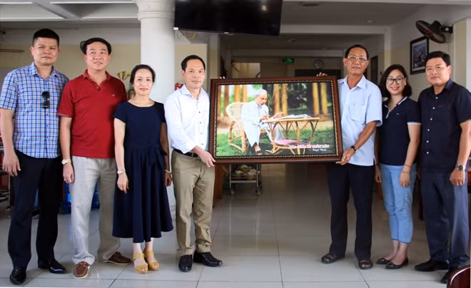 Đoàn Công tác Báo CAND tặng tranh Bác Hồ cho Ban Giám đốc Công an tỉnh An Giang.