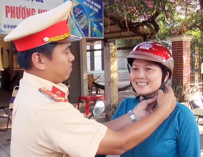 CSGT Công an tỉnh Bến Tre hướng dẫn người dân đội mũ bảo hiểm đúng quy định