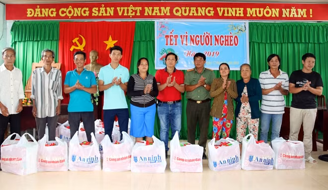Ông Lưu Quốc Quyền cùng đại diện Công an huyện Phụng Hiệp trao quà cho bà con.