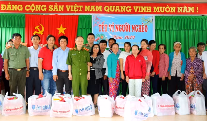 Trung tướng Nguyễn Xuân Xinh cùng đại diện Báo CAND, Công an tỉnh Hậu Giang, các Mạnh thường quân trao 60 phần quà cho bà con khó khăn xã Phụng Hiệp.
