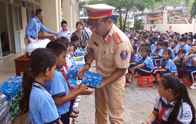 Đại diện Đội CSGT Công an huyện Phú Quốc (Kiên Giang) trao tặng tập cho học sinh.