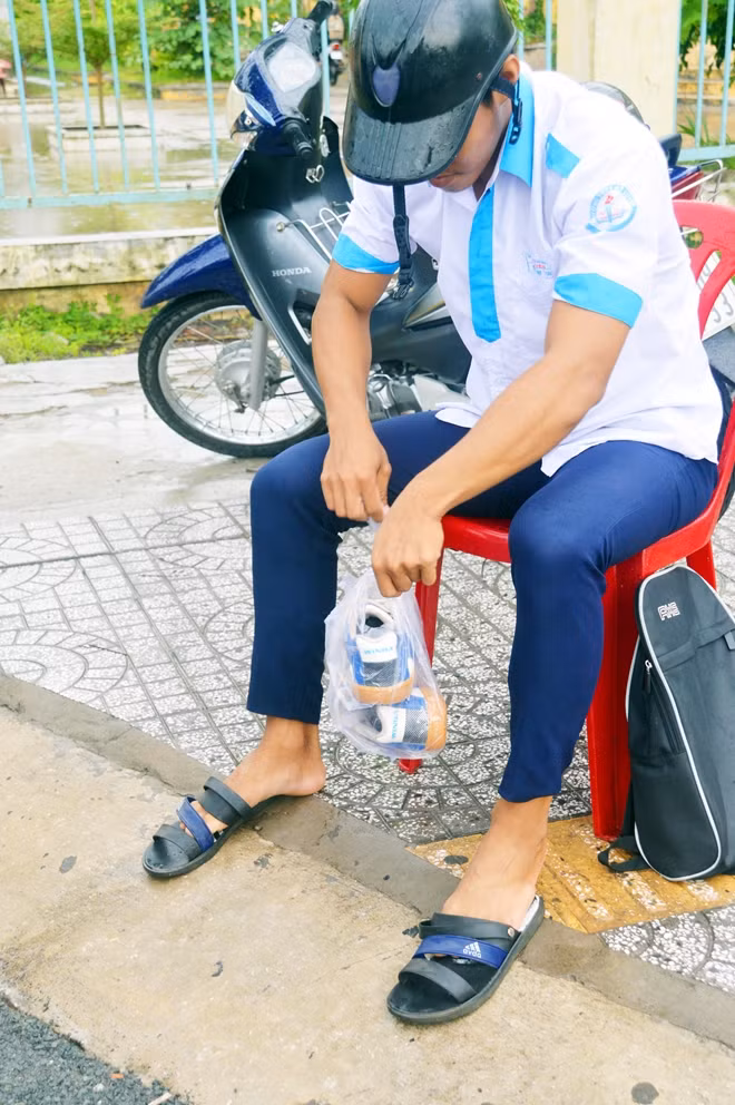 Có thí sinh phòng xa bằng cách mang giày nhưng dự phòng theo đôi dép nên khi có mưa, nước ngập thì em tháo giày cất vào ba lô, sử dụng dép đi vào phòng thi.