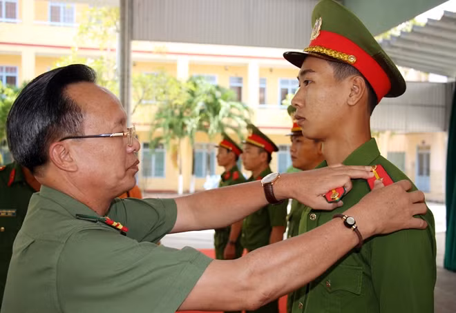 Đại tá Nguyễn Văn Phương - Phó Cục trưởng Cục Tổ chức cán bộ Bộ Công an gắn quân hàm cho các học viên tốt nghiệp.