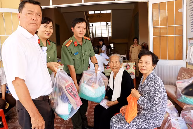 Thiếu tá Nguyễn Đức Hậu, Trưởng phòng Hậu Cần Công an tỉnh An Giang cùng các Mạnh thường quân tặng quà cho bà con khó khăn.