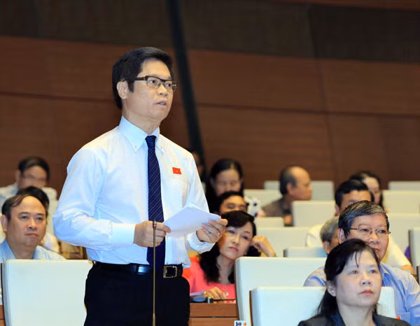 Đại biểu Vũ Tiến Lộc chất vấn thành viên Chính phủ. Ảnh: TTXVN.
