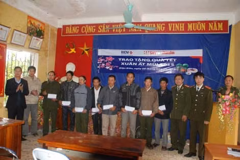 Đại tá Hà Văn Thể, Trưởng ban Kinh tế- văn hóa- xã hội Báo CAND và đại diện lãnh đạo Ngân hàng BIDV, lãnh đạo Công an tỉnh Điện Biên tặng quà Tết người nghèo xã Thanh Hưng.