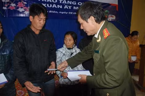 Đại tá Hà Văn Thể, Trưởng ban Kinh tế- văn hóa- xã hội Báo CAND trao tặng quà Tết người nghèo xã Thanh Hưng.