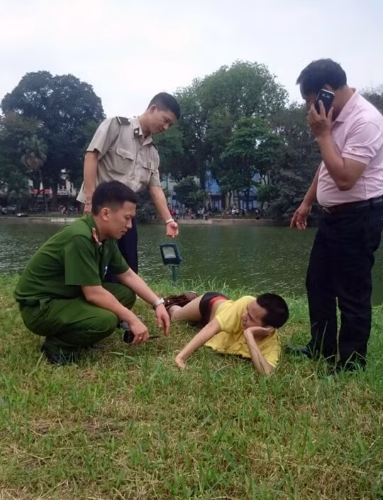 Tưởng mình là nàng tiên cá, nam thanh niên tạo dáng, “phơi mình” bên Tháp Rùa.