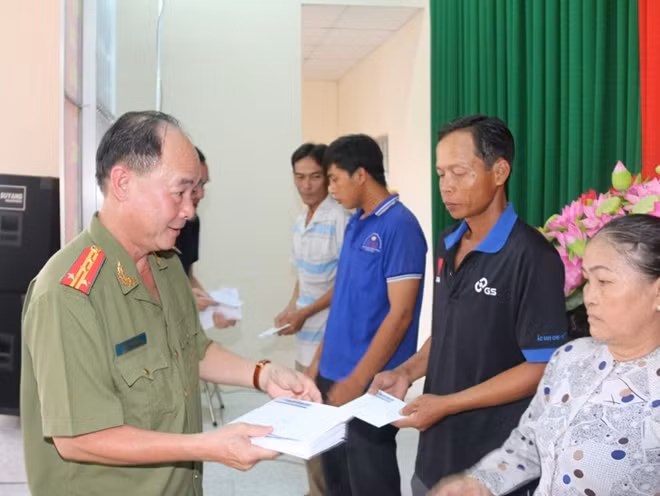 Đại tá Trần Kim Thẩm, Phó Tổng Biên tập Báo CAND tặng quà đồng bào nghèo bị ảnh hưởng bởi hạn, mặn xã Long Đức.