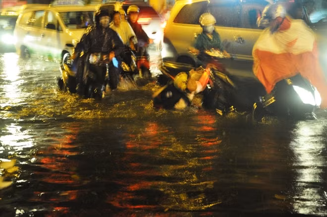 Một người lưu thông trên đường bị ngã do không nhìn thấy ổ gà dưới nước sâu