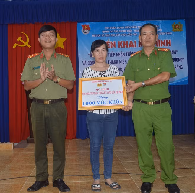 Trao móc khóa tiếp nhận thông tin tố giác tội phạm cho người dân.