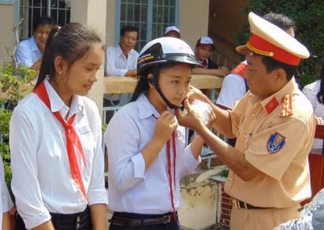 Lãnh đạo Phòng CSGT Công an tỉnh Bạc Liêu, tặng mũ bảo hiểm đạt chất lượng cho các em học sinh.