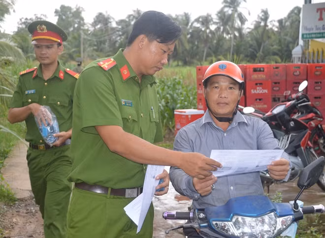 Phát tờ rơi tuyên truyền về pháp luật cho bà con.