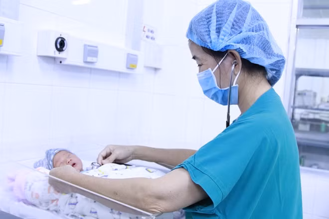 BS đang thăm khám con của sản phụ D.