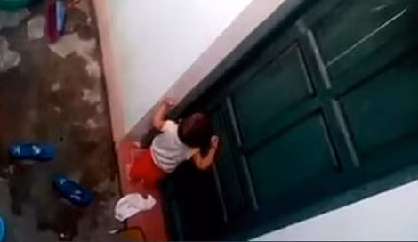 Cháu bé bị nhốt nhặt rác ăn ( ảnh từ clip). Cháu bé bị nhốt nhặt rác ăn ( ảnh từ clip).