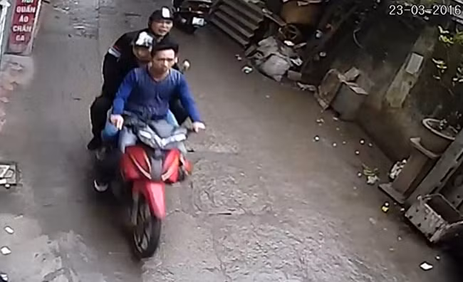 Cả ba ngồi trên chiếc xe máy Yamaha Jupiter MX màu đỏ. Ảnh cắt từ video.