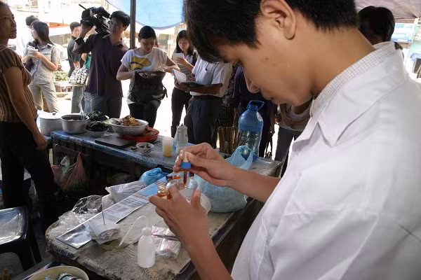 Cán bộ Y tế dự phòng TP Hồ Chí Minh thực hiện lấy mẫu thực phẩm tại khu vực chợ để kiểm tra, đánh giá các chỉ tiêu thực phẩm.