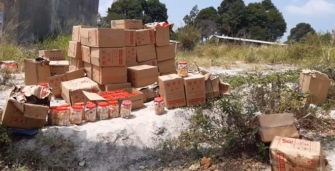 Bánh kẹo ngấm nước được người dân hỗ trợ tài xế vớt lên bờ.