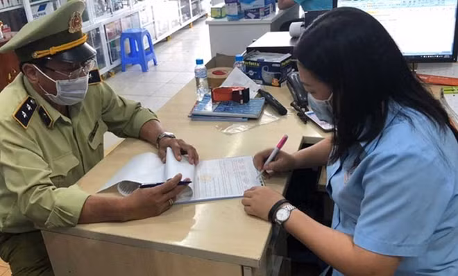 Cán bộ QLTT lập biên bản một cơ sở vi phạm