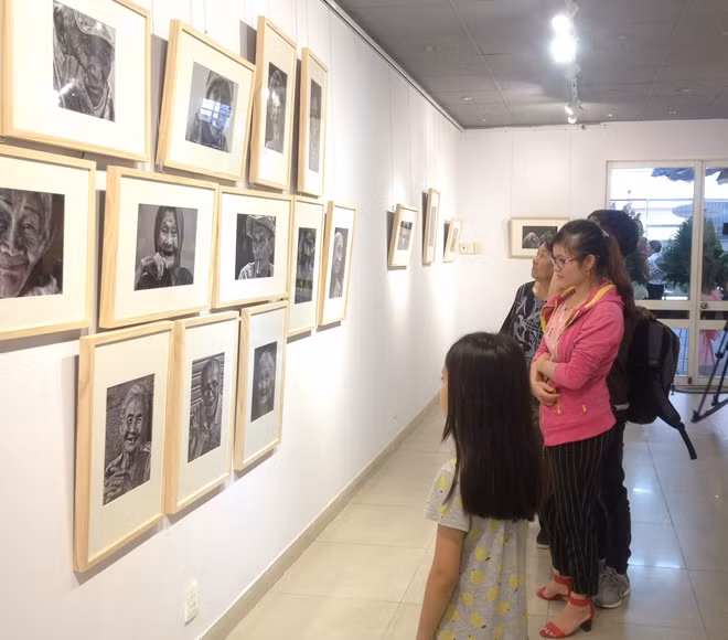 Khách tham quan thưởng thức các bức ảnh tại triển lãm.