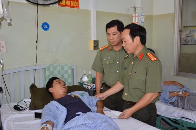 Đại diện Báo CAND và đại diện Công an tỉnh Bình Thuận trao tiền hỗ trợ cho các CBCS bị thương. (trong ảnh là thăm hỏi đồng chí Nguyễn Ngọc Đông Triều, sinh viên Trường Cao đẳng Cảnh sát nhân dân đang thực tập tại Công an TP Phan Thiết).