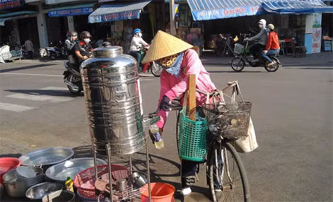 Người lao động uống nước trà đá miễn phí tại bình nước của ông Dũng (đoạn giao giữa đường Phan Bội Châu và Lê Lợi, TP Quy Nhơn).