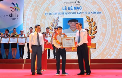 Phó Thủ tướng Vũ Đức Đam, Bộ trưởng Bộ LĐTB&XH Đào Ngọc Dung trao hoa và giấy chứng nhận cho thí sinh Triệu Văn Đài, giải nhất nghề Mộc mĩ nghệ.