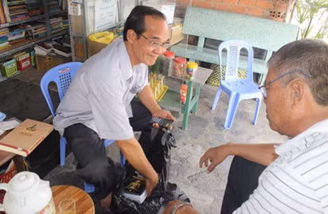 Ông Cần niềm nở giới thiệu sách với độc giả.