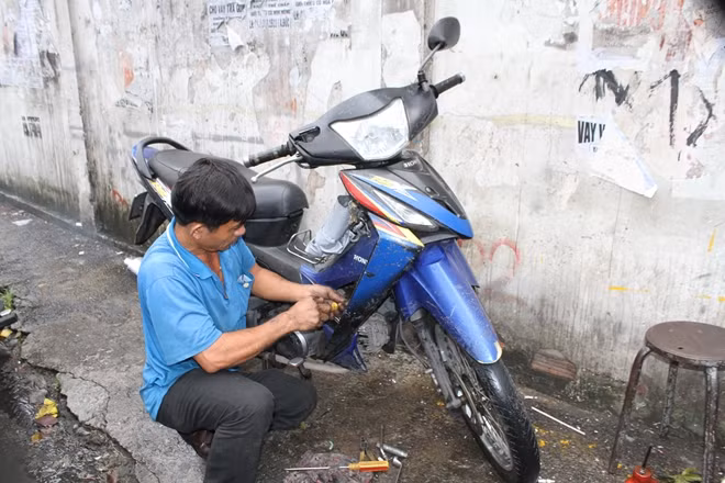 Thợ sửa xe trên đường Chu Văn An (Bình Thạnh) sửa xe bị ngập nước